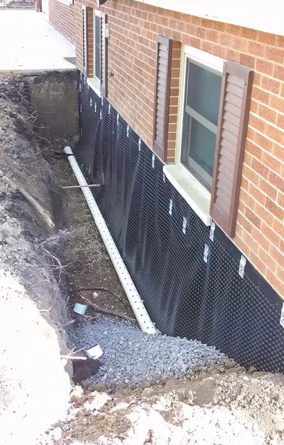 Exterior basement excavation with waterproof membrane and drainage pipe